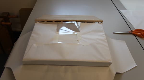 The manuscript is protected from soiling during covering with a ‘cap’ of paper and sheets of Melinex.