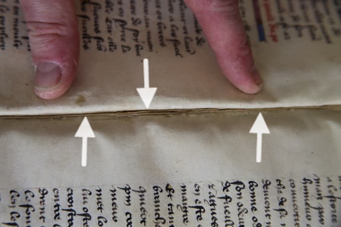 A fragment of the original sewing thread survives alongside the eighteenth-century sewing
